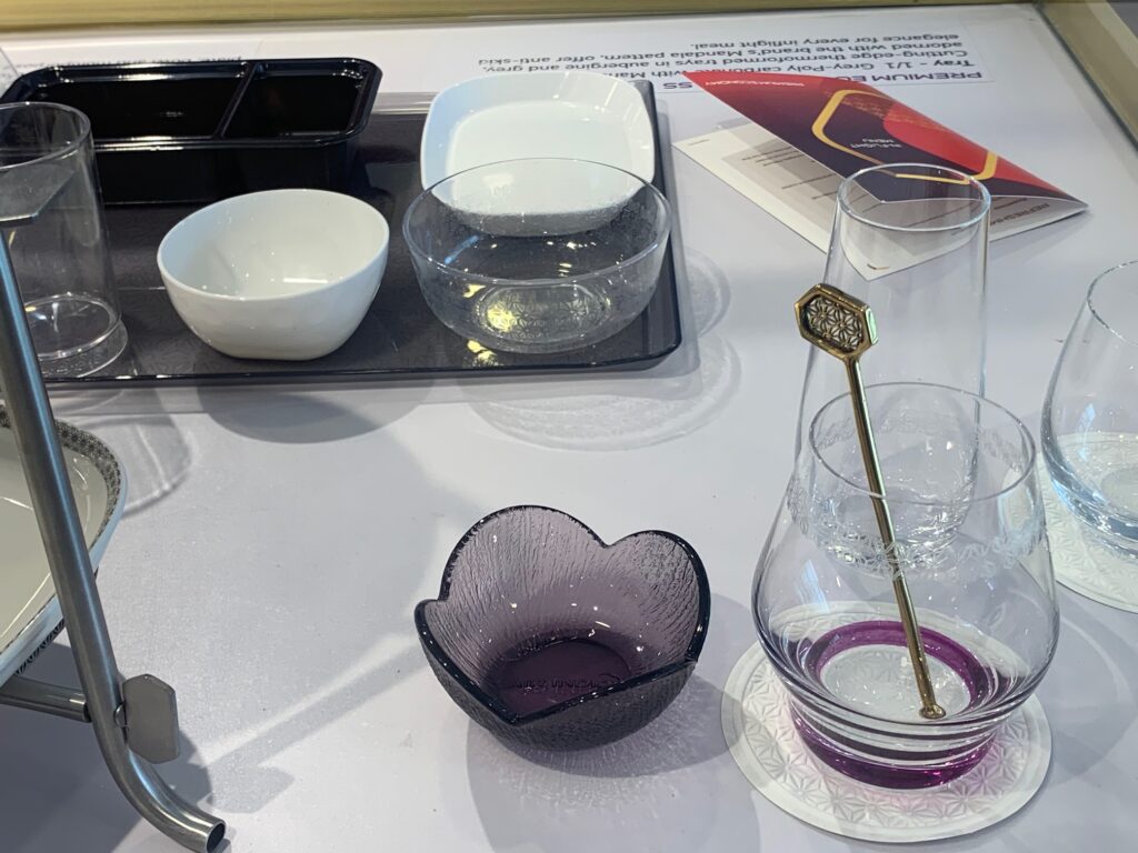 Various glassware that will be used by Air India in-flight. The drinks stirrer is gold and has an intricate design at the top.