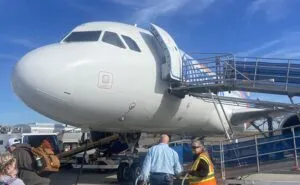 The nose of the Allegiant aircraft as it is being boarded via ramp