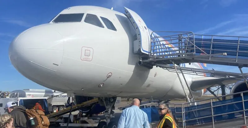 The nose of the Allegiant aircraft as it is being boarded via ramp