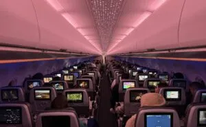 Inside a JetBlue A321neoLR: a view from the back of economy class, looking forward at passengers using their IFE screens.