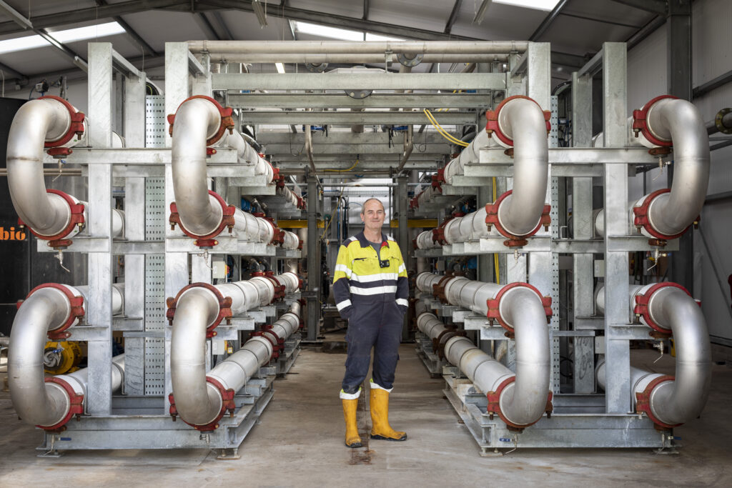 A man is standing in front of the Scottish Leather Group’s tannery facility at Bridge of Weir