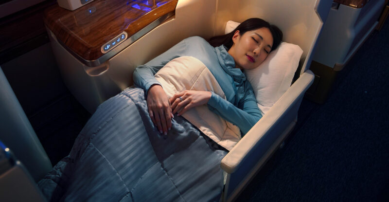 A female passenger is asleep in Emirates Business Class Loungewear