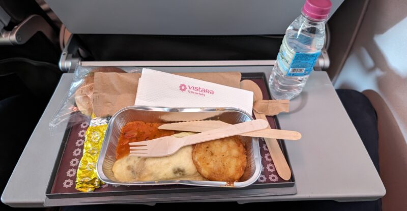 An omelet is served in-flight and displayed with a bottle of water.