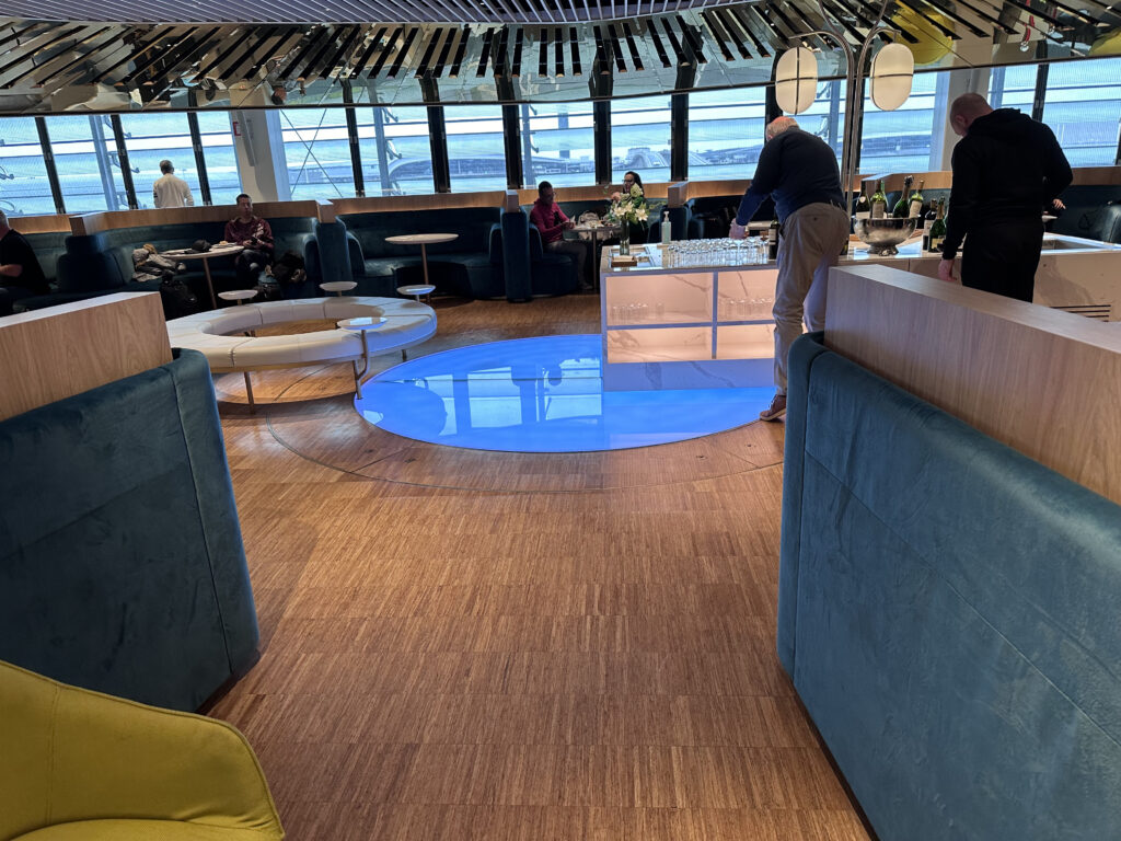 A cream coloured donut sofa sits beside a large bright blue decorative 'cloud' circle is in the middle of the lounge.