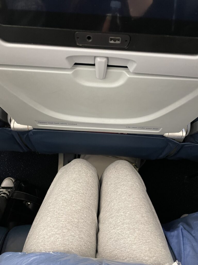 A woman's knees are seen just a couple inches from the seat in front of her on the A330neo.