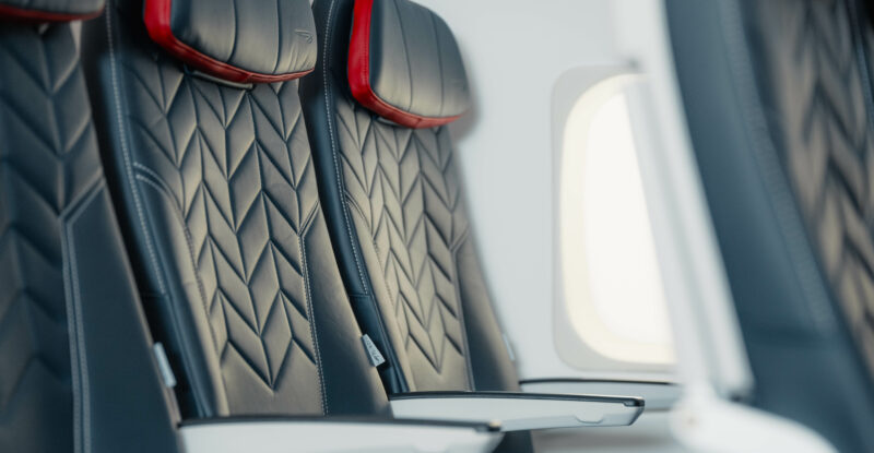 A close up of the Collins Meridian seat chosen by British Airways (BA) shows an arrow like pattern and red detailing around the headrest.