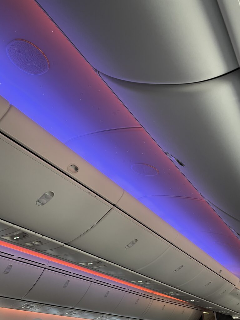 Purple LED lights over the overhead bins. Tiny 'star' lights are in view.