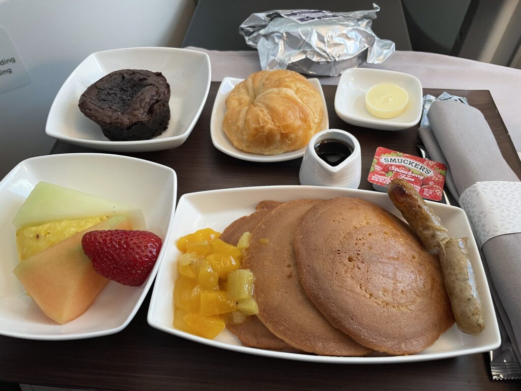 A display of pancakes, fruit and other items for brunch on the flight. 