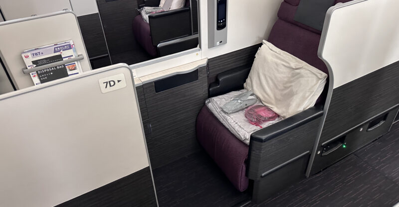 JAL business class 787 Collins Apex seat. The seat is a burgundy with grey detailing.
