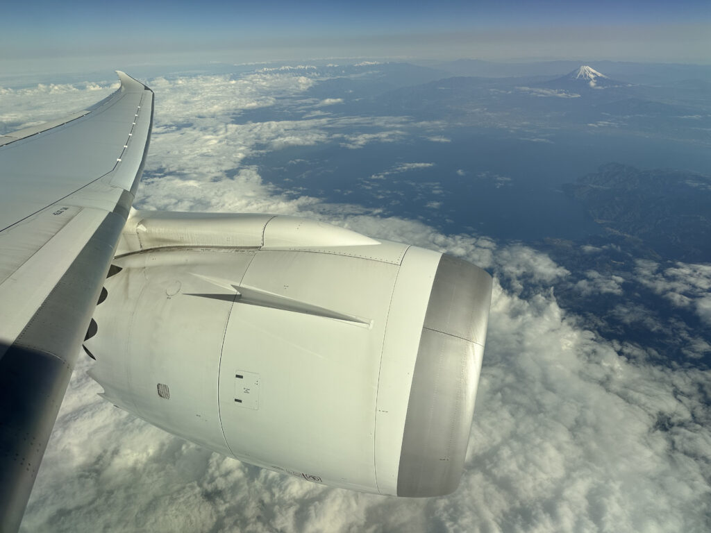 Looking out the 787 aircraft window over the jet engine, with Mount Fuji in the background.