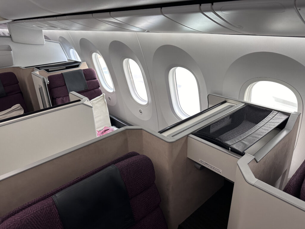 A broader view of the business class cabin with multiple seats in the photo.