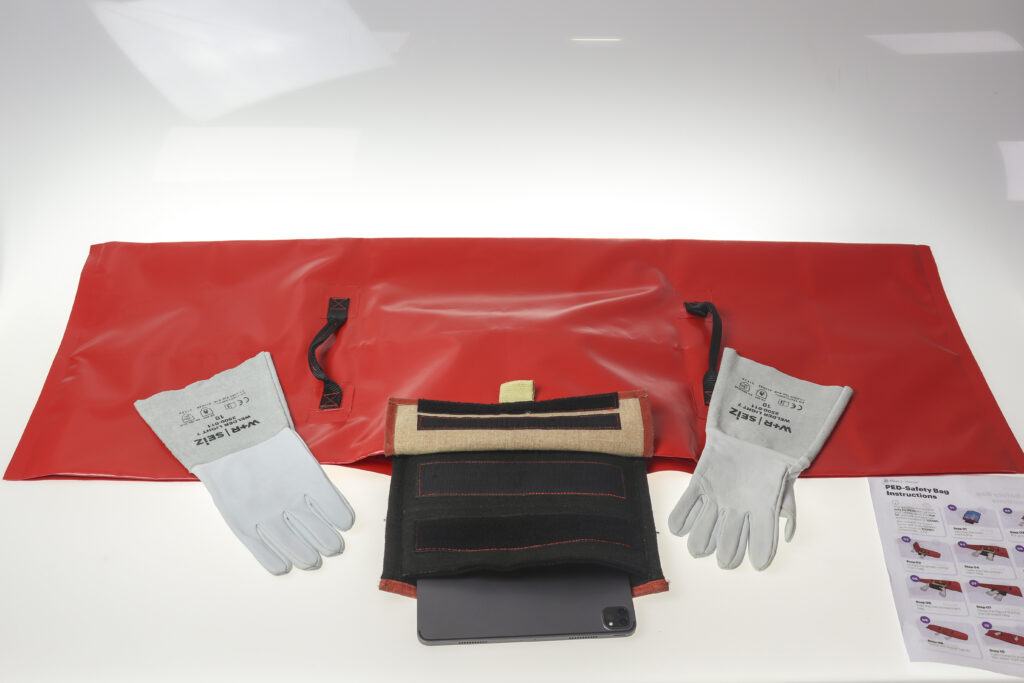 Accenture PED safety bag by Accenture GmbH is pictured in red, with gloves to protect crew members' hands.