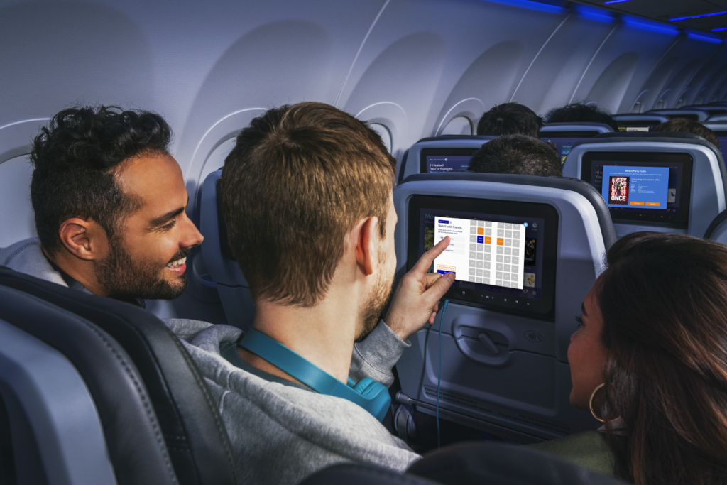 Two passengers highlight the passengers they want to enjoy a Blueprint by JetBlue watch party with by selecting seats on the IFE screen.