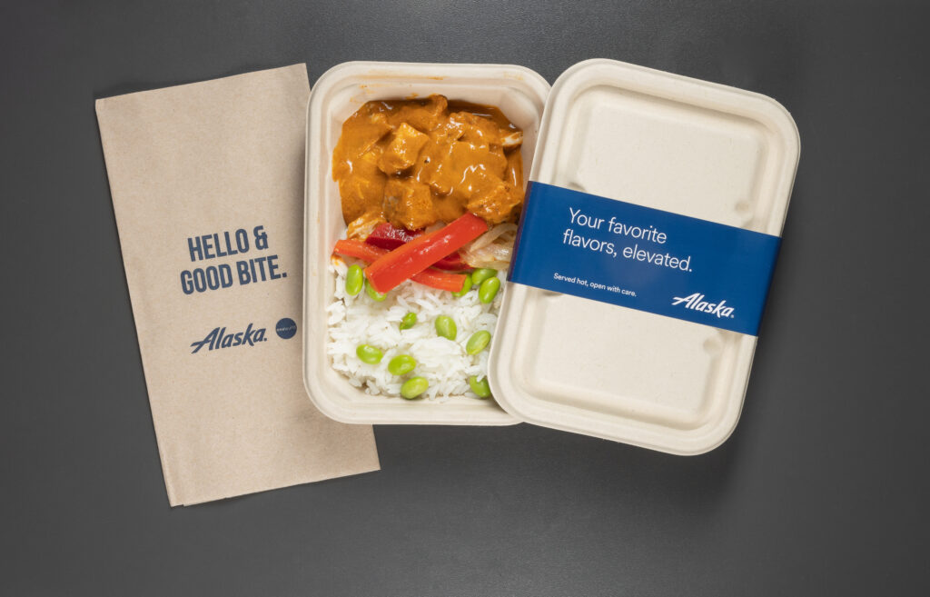 Panang Curry Chicken is displayed against a grey background alongside an Alaska Airlines napkin