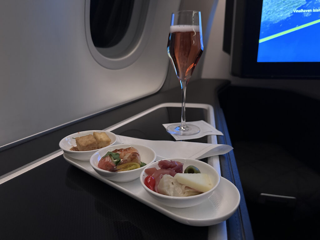 Three small dishes are set out in a row with a glass of Champers behind it.