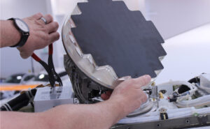 Satcom Direct Plane Simple® Ka-band terminal is pictured in a man's hands.