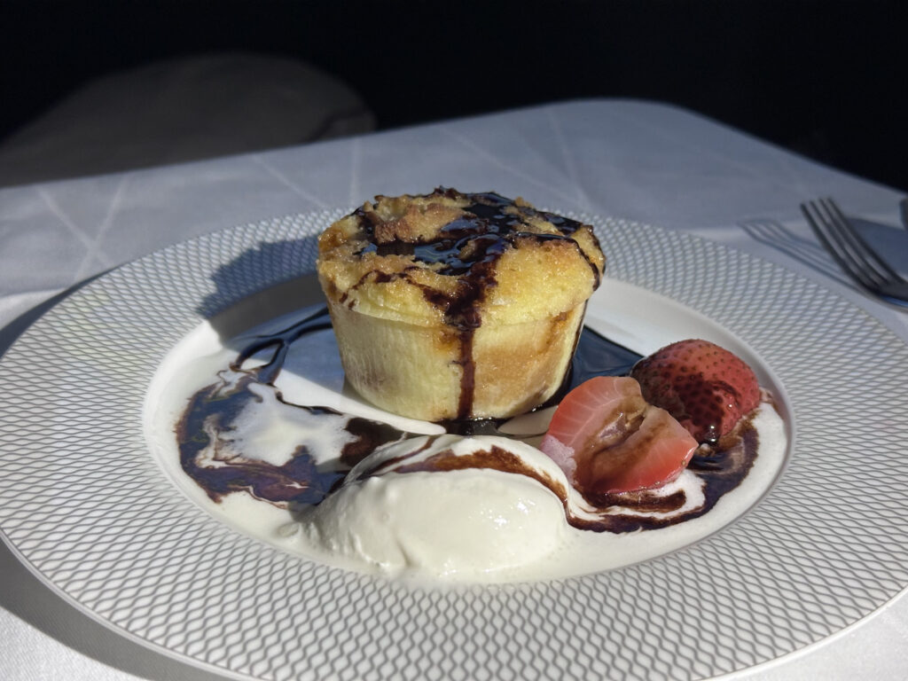 A pudding is displayed with ice cream and strawberries.