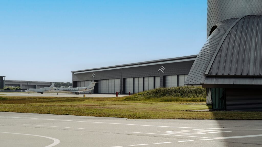 Another angle of the Farnborough Airport Domus III facility from the outside. A variety of bizjets sit in front of the facility. 