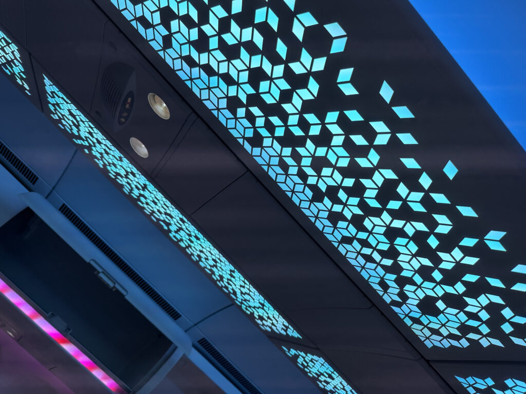 A geometric light pattern is seen on the ceiling of the aircraft display as part of the hero light, at Airbus' booth at AIX 2024