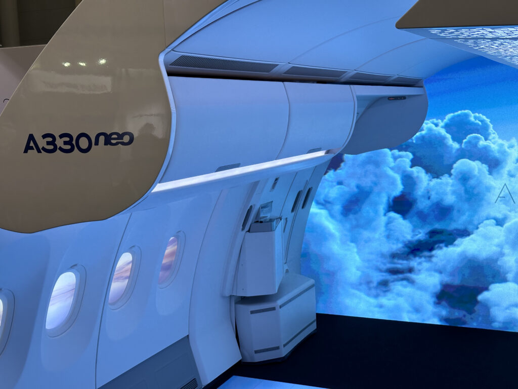 The Airbus cabin display at AIX 2024 is accented with blue LED lights and cloud like imagery