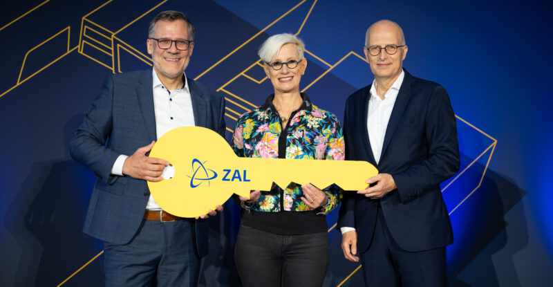 Anke Kaysser-Pyzalla, Peter Tschentscher, and Erster Bürgermeister are holding a large yellow ZAL key. Foto: Daniel Reinhardt/ZAL