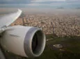 Looking out the AeroMexico aircraft over a city. The wing and engine are in view.