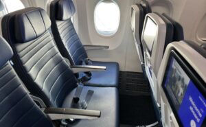 A seat triple on a United Airlines 737 MAX 8 with the IFE screens in view. United and DISH have inked an agreement to bring live sports to passengers during football season.