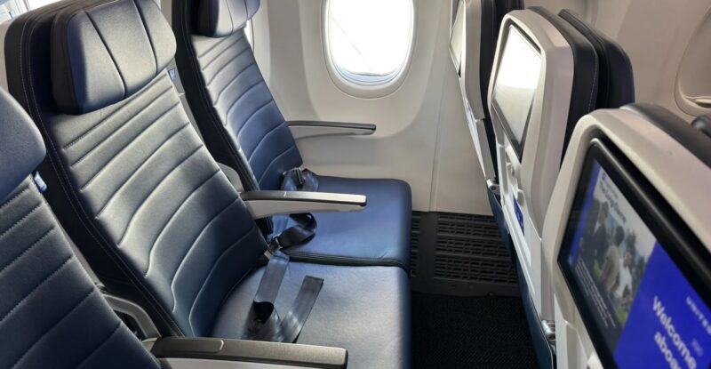 A seat triple on a United Airlines 737 MAX 8 with the IFE screens in view. United and DISH have inked an agreement to bring live sports to passengers during football season.