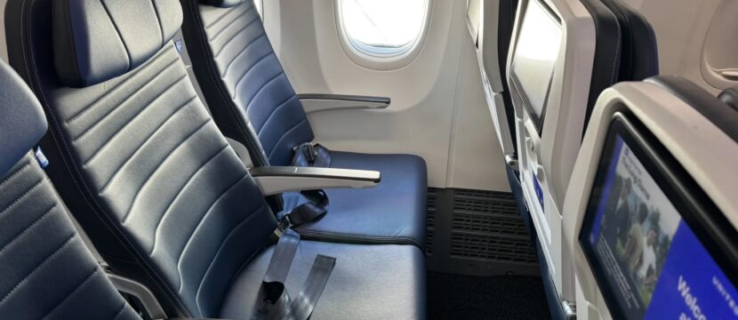 A seat triple on a United Airlines 737 MAX 8 with the IFE screens in view. United and DISH have inked an agreement to bring live sports to passengers during football season.