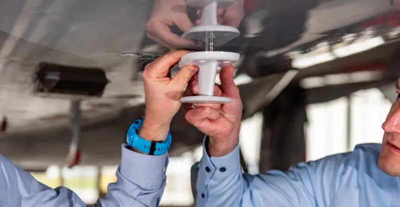 Two people are installing A2G onto an aircraft.