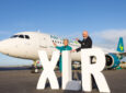Aer Lingus A321XLR arrives in Dublin. Two members of the crew stand with giant white block letters saying XLR