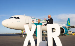Aer Lingus A321XLR arrives in Dublin. Two members of the crew stand with giant white block letters saying XLR