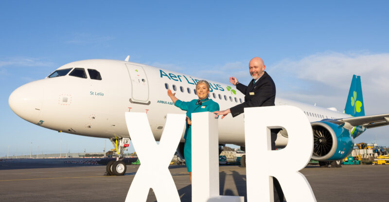 Aer Lingus A321XLR arrives in Dublin. Two members of the crew stand with giant white block letters saying XLR