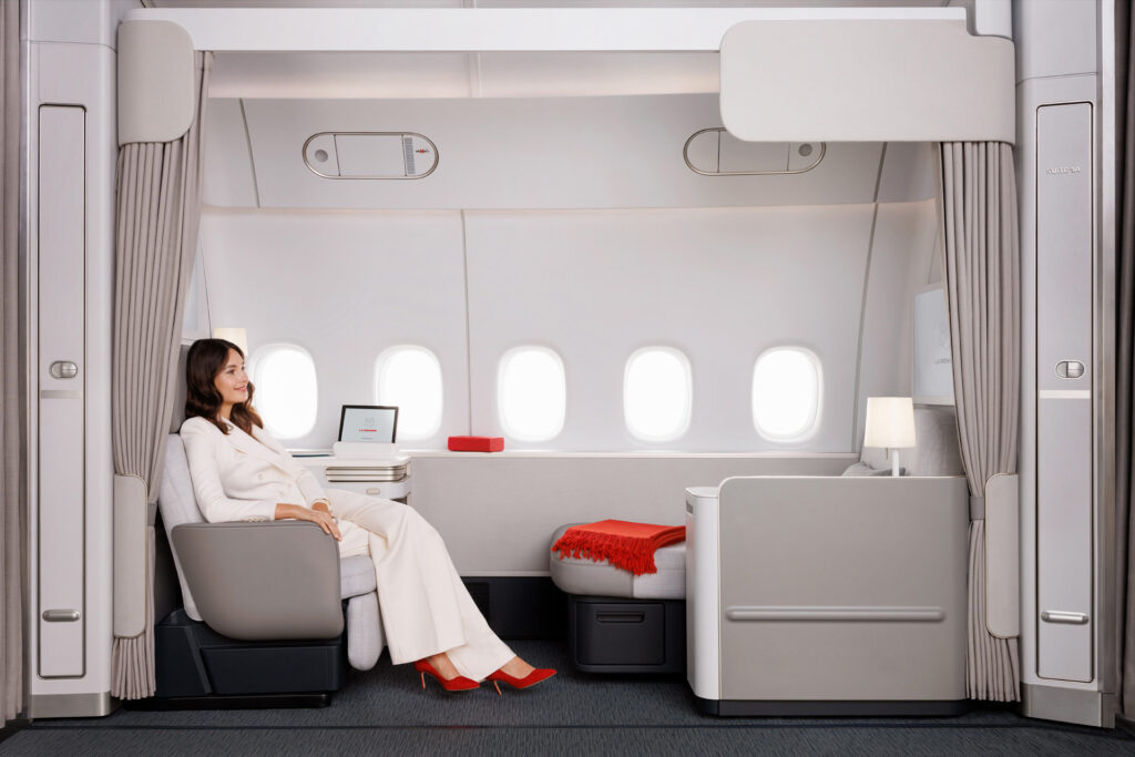 Side view of the Air France first class space, which stretches a full five windows. A woman passenger sits in the armchair.