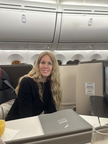 The author, Mary Kirby, smiling whilst seated in Austrian business class.