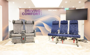 A set of three Recaro R3 seats in blue and a grey set of two Recaro R4 seats are on display at AIX 2025