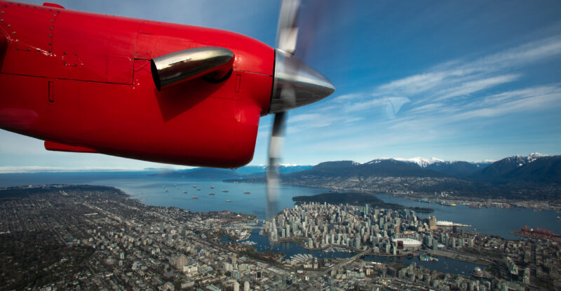 Harbour Air red prop engine as seen from inside the aircraft in flight over Victoria Harbour