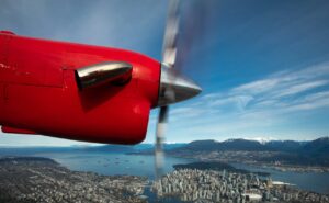 Harbour Air red prop engine as seen from inside the aircraft in flight over Victoria Harbour