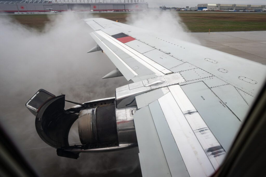 Aircraft wing as seen from the cabin window on takeoff.