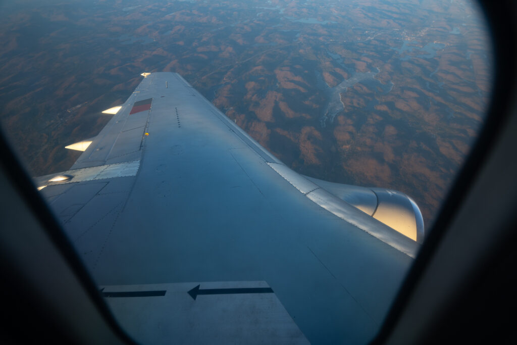 Looking out the cabin window at the wing whilst the aircraft is in flight.