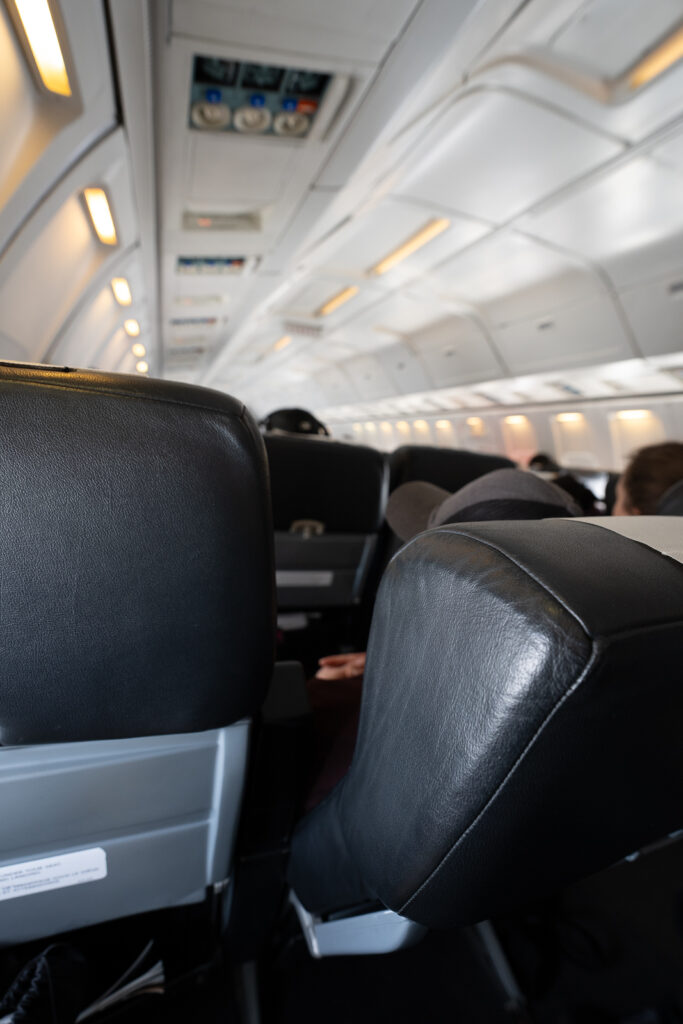 A seat in front of the passenger is in deep recline mode