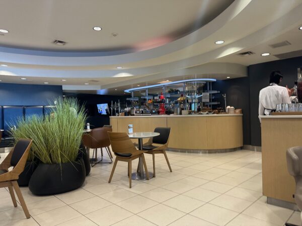 Chairs and small tables in front of the buffet in the Lufthansa business class lounge at IAD