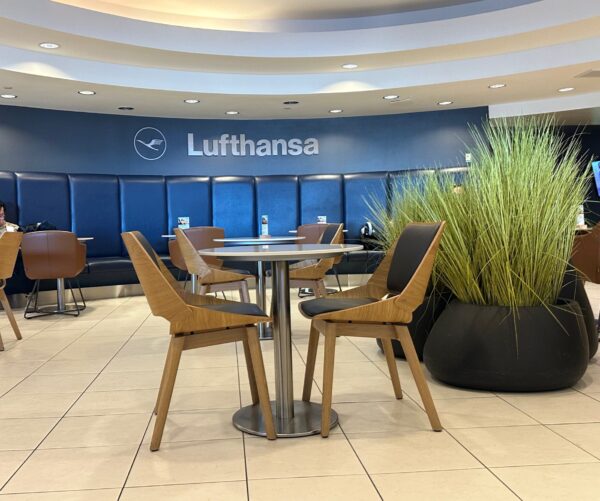 Lufthansa name and logo in white against a blue wall in the Lufthansa business class lounge at IAD