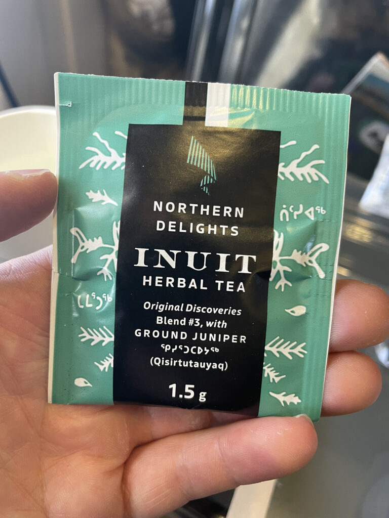 A passenger is holding up a package of Inuit herbal tea