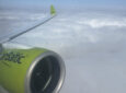 Engine and wing of airBaltic A220, in the carrier's signature green, as seen through a cabin window on this Brussels Airlines flight.