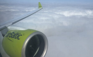 Engine and wing of airBaltic A220, in the carrier's signature green, as seen through a cabin window on this Brussels Airlines flight.