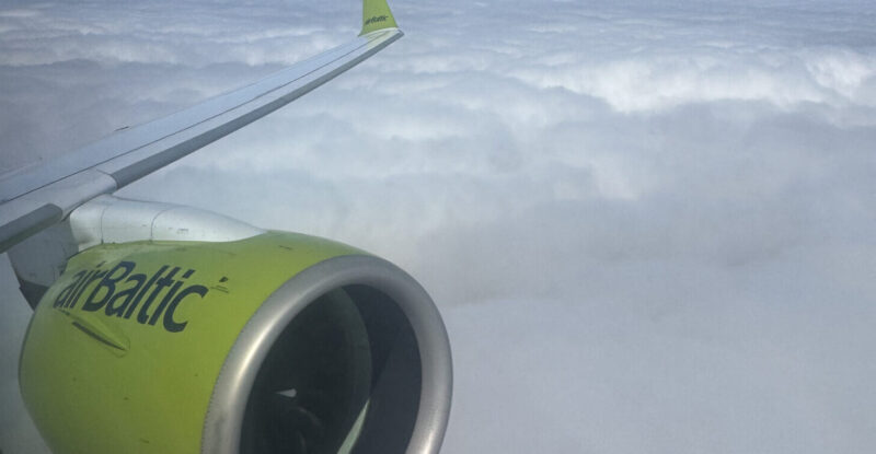 Engine and wing of airBaltic A220, in the carrier's signature green, as seen through a cabin window on this Brussels Airlines flight.