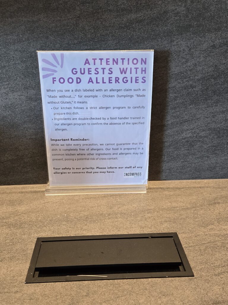 A sign alerting passengers of how the lounge approaches allergen labels 