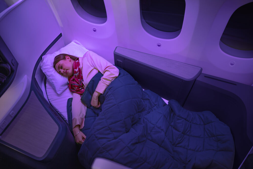 A woman is sleeping in the Business Premier Luxe suite.