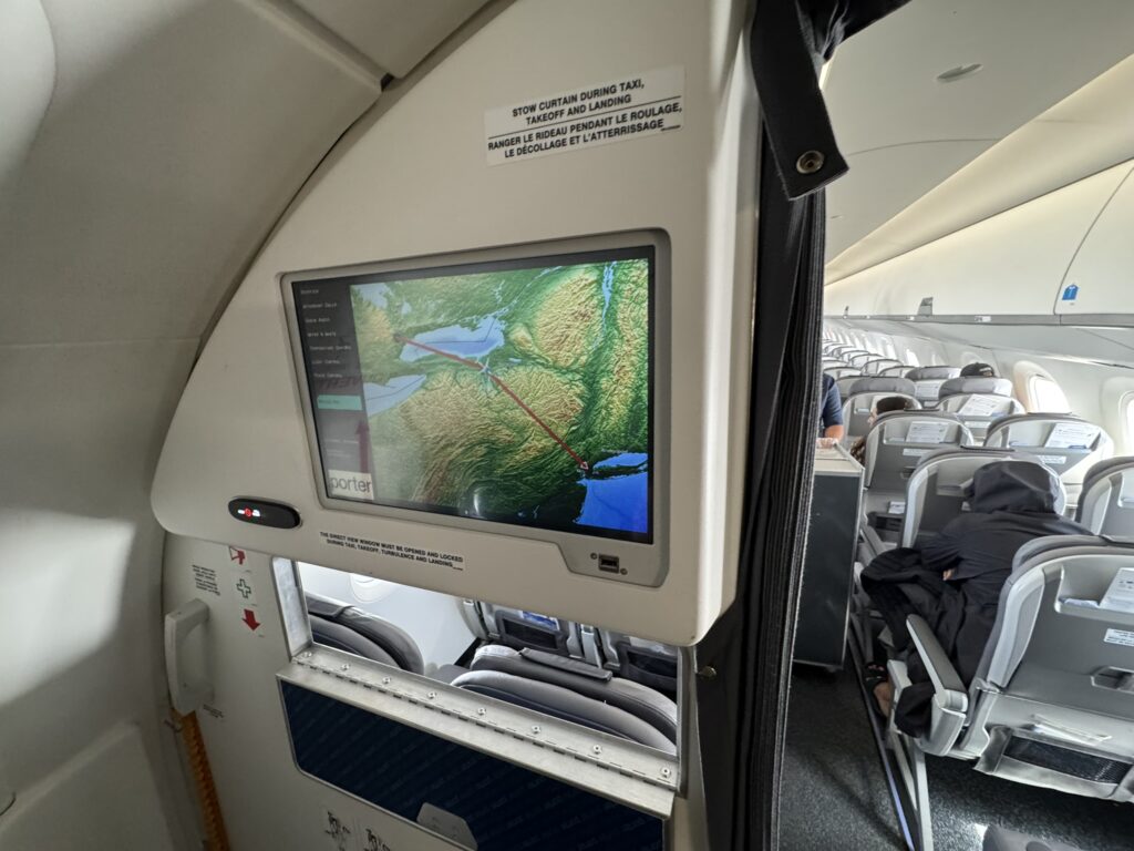 View from the back of E2 shows a large screen mounted to a rear monument, featuring a moving map with the aircraft's route. 